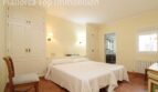 Helles Schlafzimmer der Villa in Alcúdia mit Doppelbett, Einbauschränken und angrenzendem Bad.