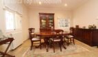 Elegantes Esszimmer der Villa in Alcúdia mit Mahagoni-Tisch, Vitrine und Sideboard auf Natursteinboden.