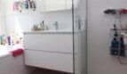 Modernes Badezimmer mit weißem Waschtischunterschrank, Glasdusche und Badewanne in Doppelhaushälfte Llucmajor