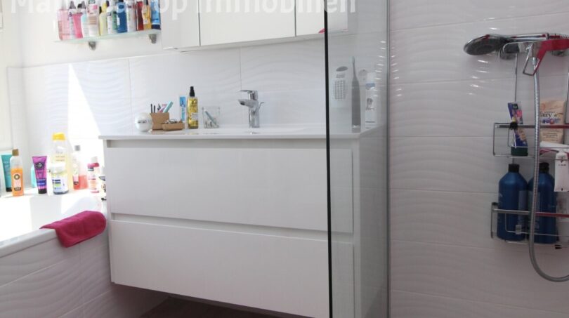 Modernes Badezimmer mit weißem Waschtischunterschrank, Glasdusche und Badewanne in Doppelhaushälfte Llucmajor