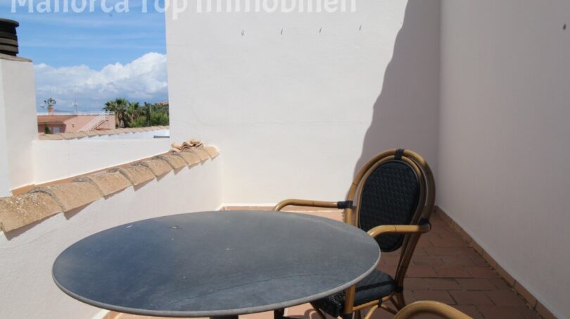 Sonnige Dachterrasse mit rundem Tisch und Stühlen, Blick auf Nachbarschaft und Meer in Llucmajor