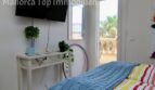 Helles Schlafzimmer mit TV, Balkonzugang und Meerblick in moderner Doppelhaushälfte in Llucmajor