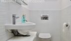 Modernes weißes Gäste-WC mit Wandhänge-WC, kleinem Waschbecken und Chromarmaturen in Doppelhaushälfte Llucmajor