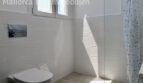 Modernes Badezimmer mit Wandhänge-WC, Dusche und weißen Strukturfliesen in Doppelhaushälfte Llucmajor