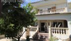 Außenansicht Doppelhaushälfte Llucmajor mit Balkon, Terrasse, Treppenaufgang und mediterranem Garten mit Palmen.