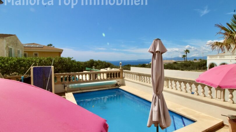 Beheizter Pool mit weißer Balustrade und Meerblick, Sonnenschirme auf der Terrasse der Doppelhaushälfte in Llucmajor