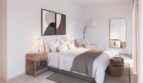 Helles Schlafzimmer der Neubau-Finca in Manacor mit Doppelbett, Holzmöbeln und modernem Wandspiegel