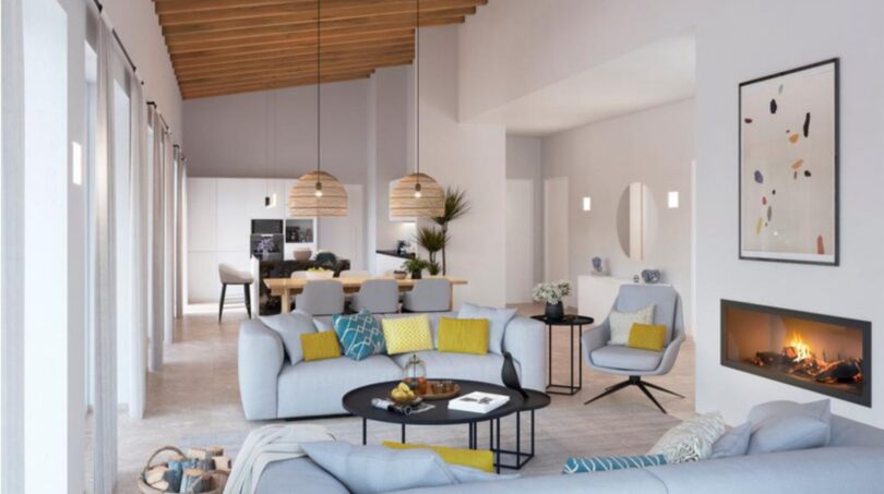 Helles Wohnzimmer der Neubau-Finca in Manacor mit Kamin, Holzdecke und modernem Open-Plan-Design