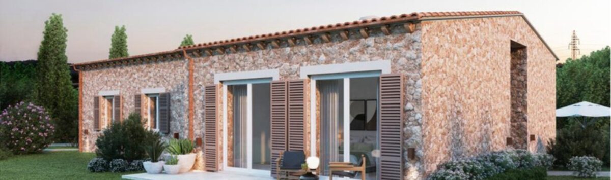Vista exterior de la nueva Finca Manacor: Villa de piedra natural con terraza, persianas de madera y jardín bien cuidado de estilo mediterráneo.