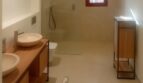 Modernes Badezimmer der Finca Manacor mit Doppelwaschbecken, bodenebener Dusche und Holzmöbeln