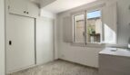 Helles Schlafzimmer mit Einbauschrank, Terrazzoboden und Fenster mit Blick auf Innenhof in Palma