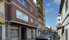 Außenansicht eines mehrstöckigen Wohngebäudes mit Ladenlokal im Erdgeschoss in einer ruhigen Straße in Palma de Mallorca.