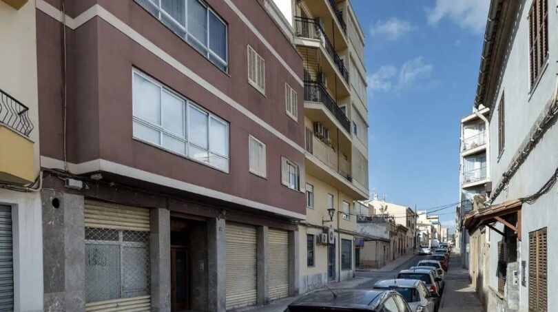 Außenansicht eines mehrstöckigen Wohngebäudes mit Ladenlokal im Erdgeschoss in einer ruhigen Straße in Palma de Mallorca.