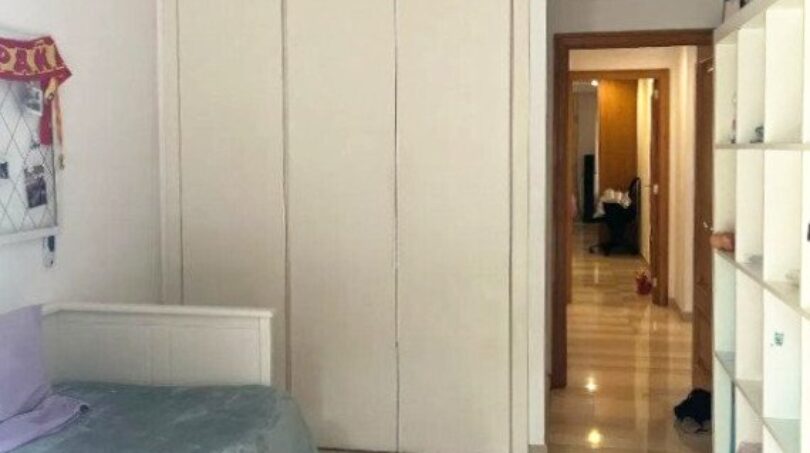 Kinderzimmer mit weißem Einbauschrank, Einzelbett, Deckenventilator und buntem Spielteppich in Erdgeschosswohnung Palma