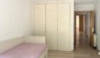 Helles Schlafzimmer mit Einzelbett, großem Einbauschrank und Zugang zum Flur in Erdgeschosswohnung Palma