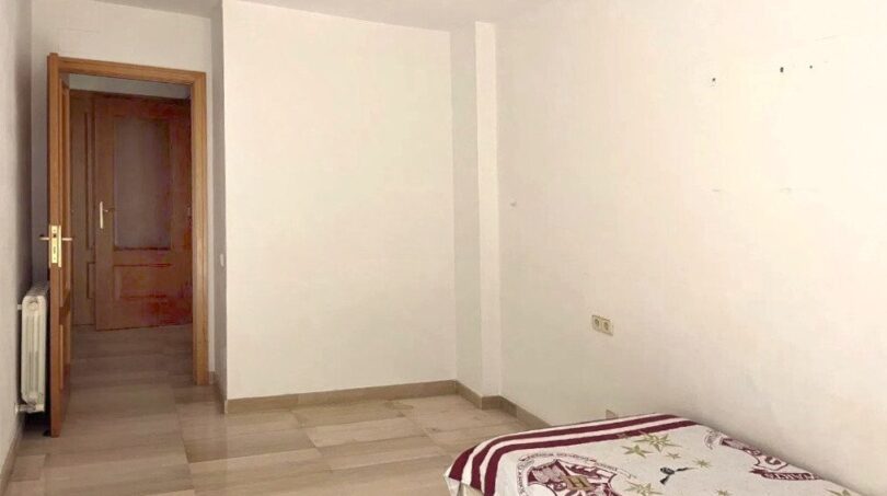 Helles Schlafzimmer mit Einzelbett, Hogwarts-Bettwäsche, Laminatboden und Holztür in Erdgeschosswohnung Palma