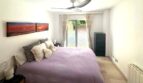 Helles Schlafzimmer mit Doppelbett, Deckenventilator und Terrassenzugang zum Garten der Erdgeschosswohnung in Palma.