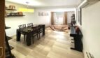 Helles Wohn-Esszimmer mit Fliesenboden, dunklem Esstisch und Terrassen-Ausblick in Erdgeschosswohnung Palma