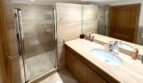 Elegantes Marmorbad mit Glasdusche, Doppelwaschbecken und Holzschränken in Erdgeschosswohnung Palma