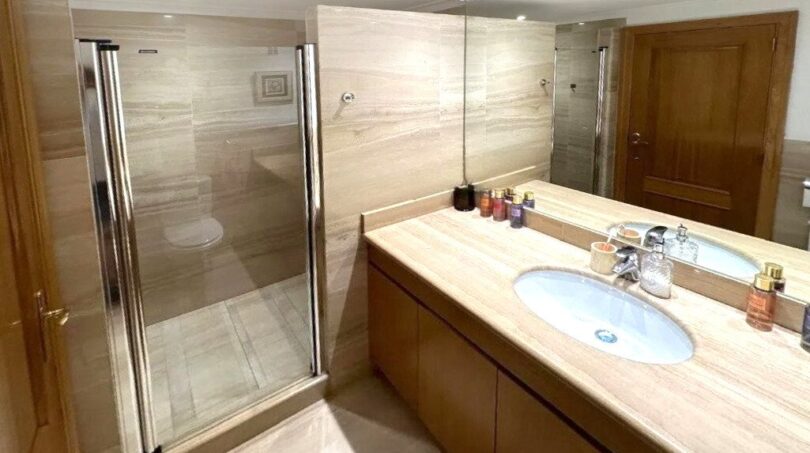 Elegantes Marmorbad mit Glasdusche, Doppelwaschbecken und Holzschränken in Erdgeschosswohnung Palma