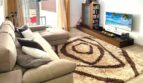 Helles Wohnzimmer mit großem Ecksofa, Flachtisch-TV und gemustertem Teppich in Erdgeschosswohnung Palma