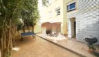 Sonnige Terrasse mit Ping-Pong-Tisch, Sitzbereich, Grill und Bäumen der Erdgeschosswohnung in Palma