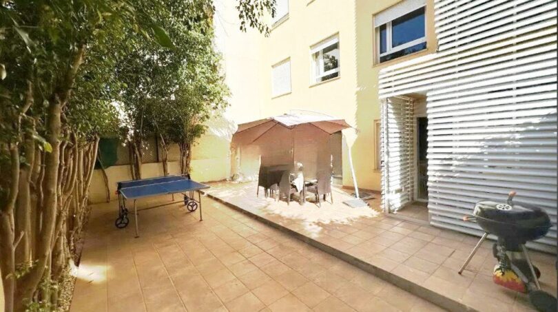 Sonnige Terrasse mit Ping-Pong-Tisch, Sitzbereich, Grill und Bäumen der Erdgeschosswohnung in Palma