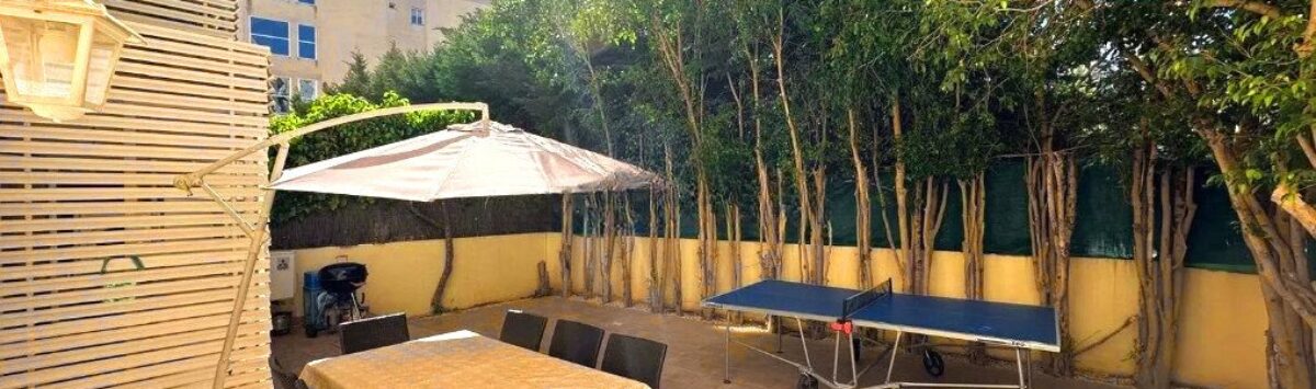 Sonnige Terrasse mit Essbereich, Sonnenschirm und Tischtennisplatte, umgeben von Bäumen in Palma de Mallorca
