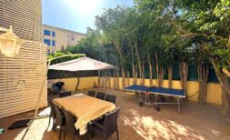Sonnige Terrasse mit Essbereich, Sonnenschirm und Tischtennisplatte, umgeben von Bäumen in Palma de Mallorca