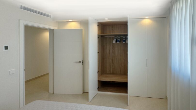 Helles Schlafzimmer mit eingebautem Holzkleiderschrank und weißen Türen in exklusiver Erstbezugswohnung, Palma