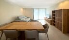 Modernes Wohn-Esszimmer mit Holztisch, grauer Couch und Einbauregal in exklusiver Erstbezug-Wohnung in Palma