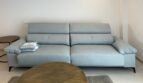 Helles Wohnzimmer mit hellblauem Designsofa und goldenem Couchtisch in exklusiver Neubauwhg Palma