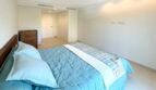 Helles Schlafzimmer mit türkisem Doppelbett, Holzkommode und modernem Einbauschrank in Palma-Neubau