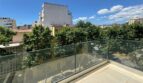 Moderne Dachterrasse mit Glasgeländer und Blick auf baumgesäumte Straße in Palma de Mallorca