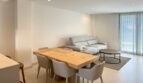 Helles Wohn-Esszimmer mit Holztisch, grauen Stühlen und Sofa in exklusiver Neubau-Eigentumswohnung Palma