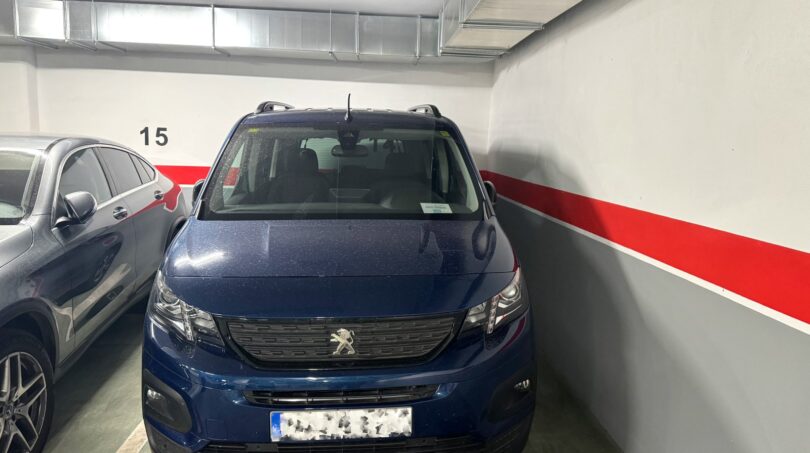 Tiefgarage mit nummeriertem Stellplatz 15, roter Wandmarkierung und blauem Peugeot, zur exklusiven Eigentumswohnung in Palma.