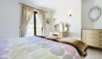Helles Schlafzimmer der Villa in Cala Vinyes mit Doppelbett, Schminktisch und Balkonzugang.