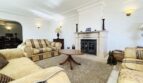 Elegantes Wohnzimmer mit Kamin, Polstermöbeln und Teppich in exklusiver Villa in Cala Vinyes