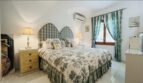 Helles Schlafzimmer der Villa in Cala Vinyes mit Doppelbett, Toile-de-Jouy-Bettwäsche und türkisen Akzenten.
