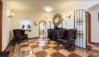 Eleganter Eingangsbereich der Villa in Cala Vinyes mit Schachbrettmarmorboden und Chesterfield-Sesseln.