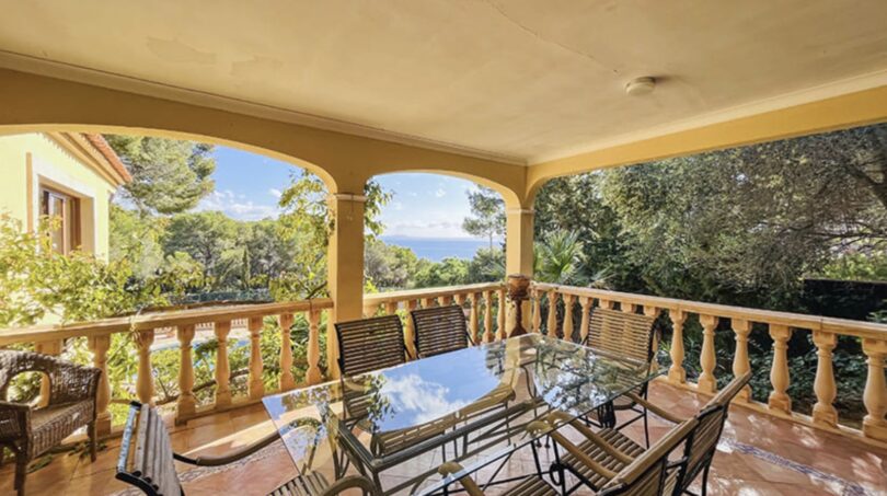 Überdachte Terrasse mit Glasstisch, Meerblick und üppiger Vegetation in exklusiver Villa, Calvia
