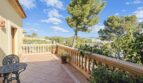 Sonnige Terrasse mit Balustrade, Gartenmöbeln und Blick auf Bäume und Berge in Villa Cala Vinyes