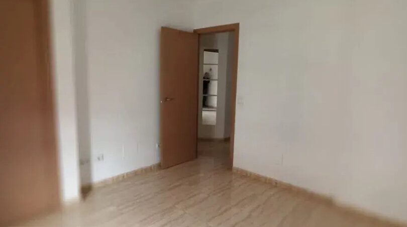 Leeres Schlafzimmer der Maisonette-Wohnung in El Molinar mit Holzlaminatboden und weißen Wänden