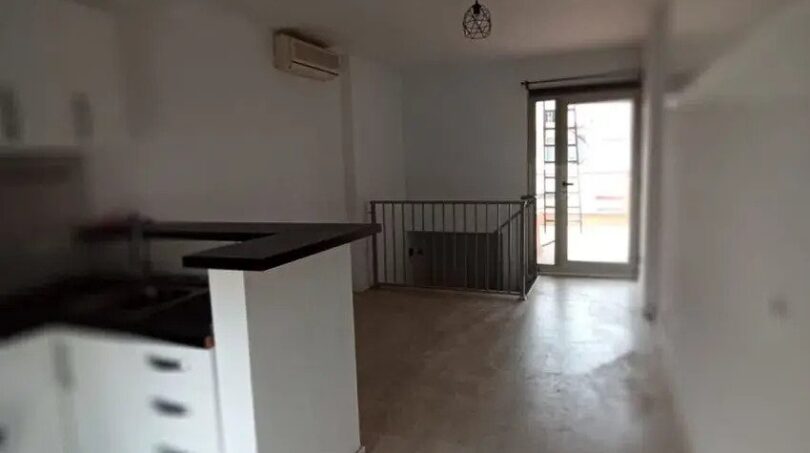 Offene Küche mit Kochinsel und Holzboden in Maisonette-Wohnung El Molinar, Blick auf Balkonzugang