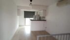Offener Wohn-Kochbereich der Maisonette mit Holzboden, Einbauküche und Treppenaufgang in El Molinar