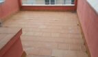 Geräumige Dachterrasse mit Terrakottafliesen und roten Brüstungsmauern der Maisonette in El Molinar, Palma