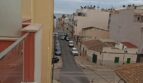 Balkonblick auf ruhige Straße in El Molinar mit Meerblick, Altstadt-Flair und mediterraner Architektur