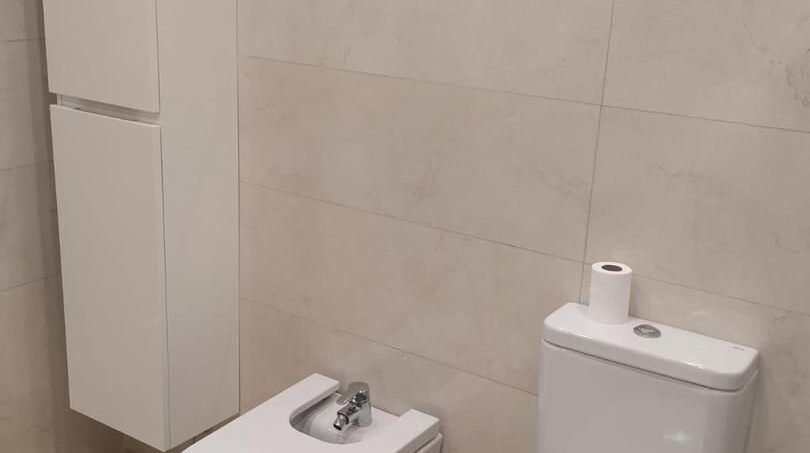 Elegantes Badezimmer mit WC, Bidet und Hochschrank in hellem Marmor-Look im Chalet Es Garrovers