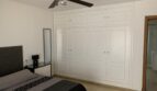 Schlafzimmer des Chalets in Marratxí mit weißem Einbauschrank, Doppelbett, Deckenventilator und angrenzendem Bad.