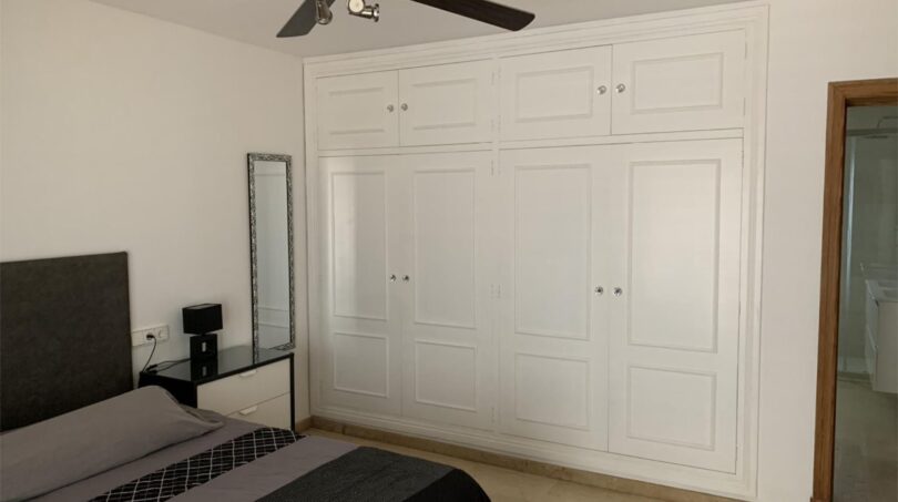 Schlafzimmer des Chalets in Marratxí mit weißem Einbauschrank, Doppelbett, Deckenventilator und angrenzendem Bad.